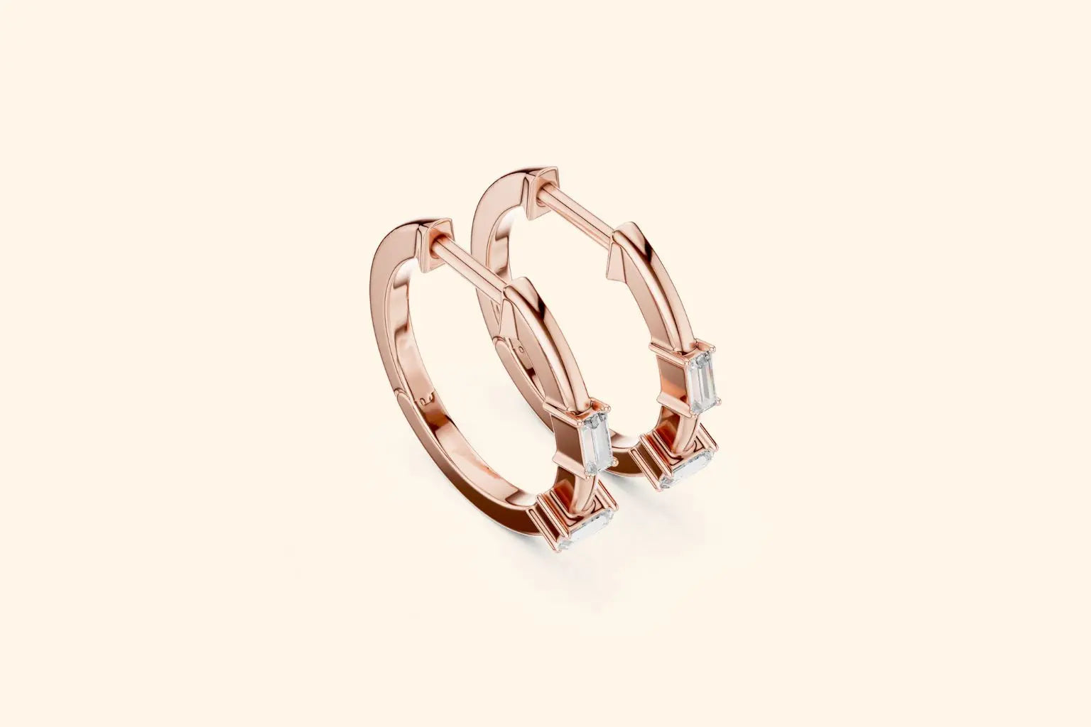 Rose gold hoop earrings with small diamonds on a light beige background