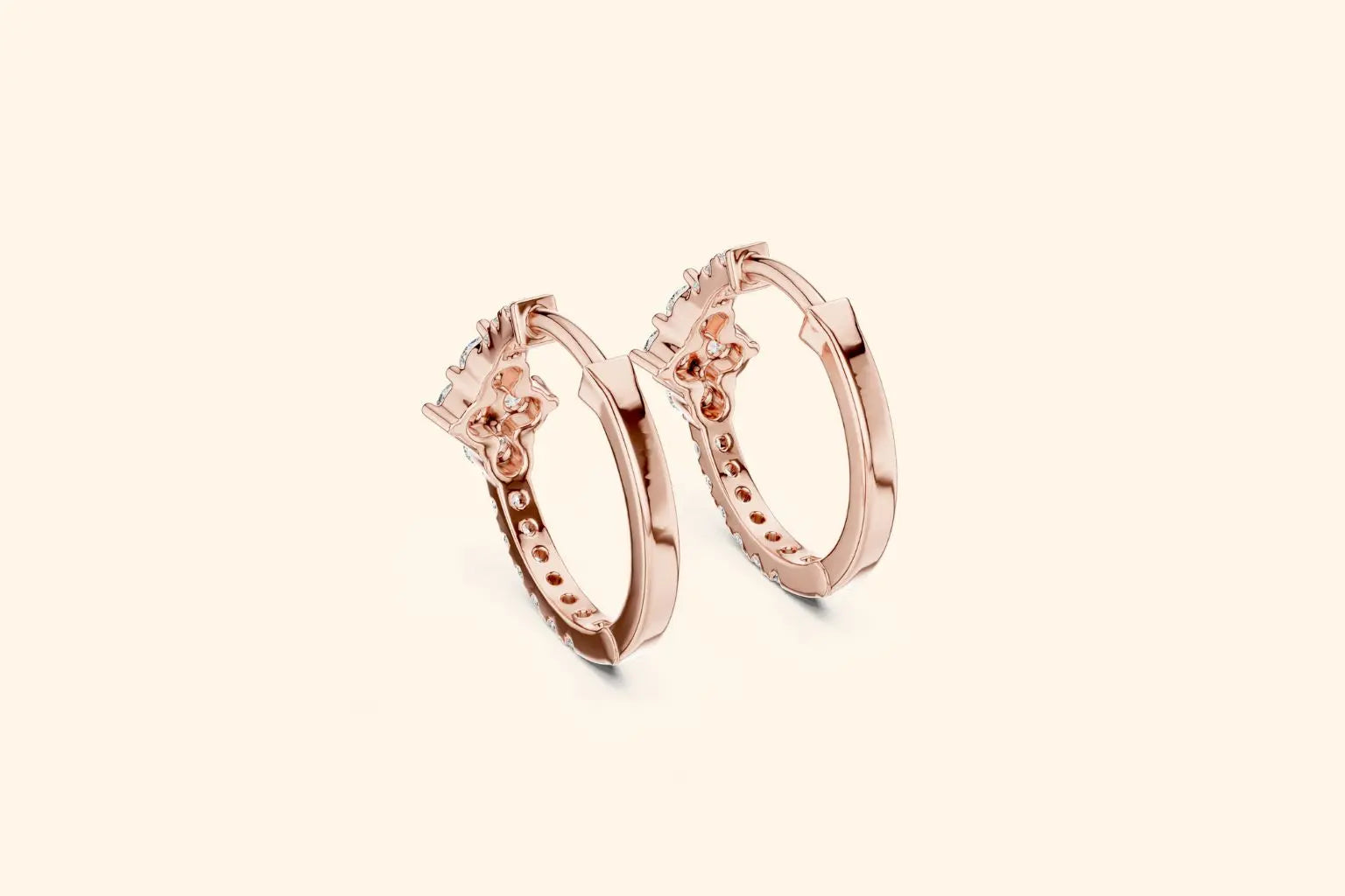 Pair of rose gold hoop earrings on a light pink background