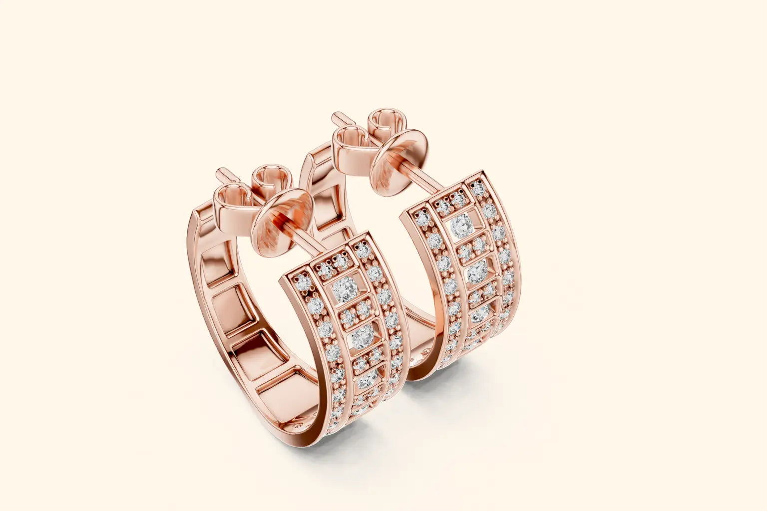 Rose gold hoop earrings with diamond accents on a light beige background