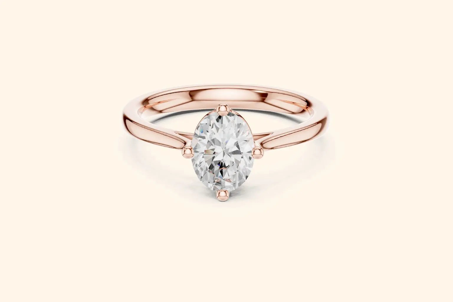 A classic solitaire engagement ring featuring an oval-cut diamond set in a sleek, four-prong compass style on a polished rose gold band.