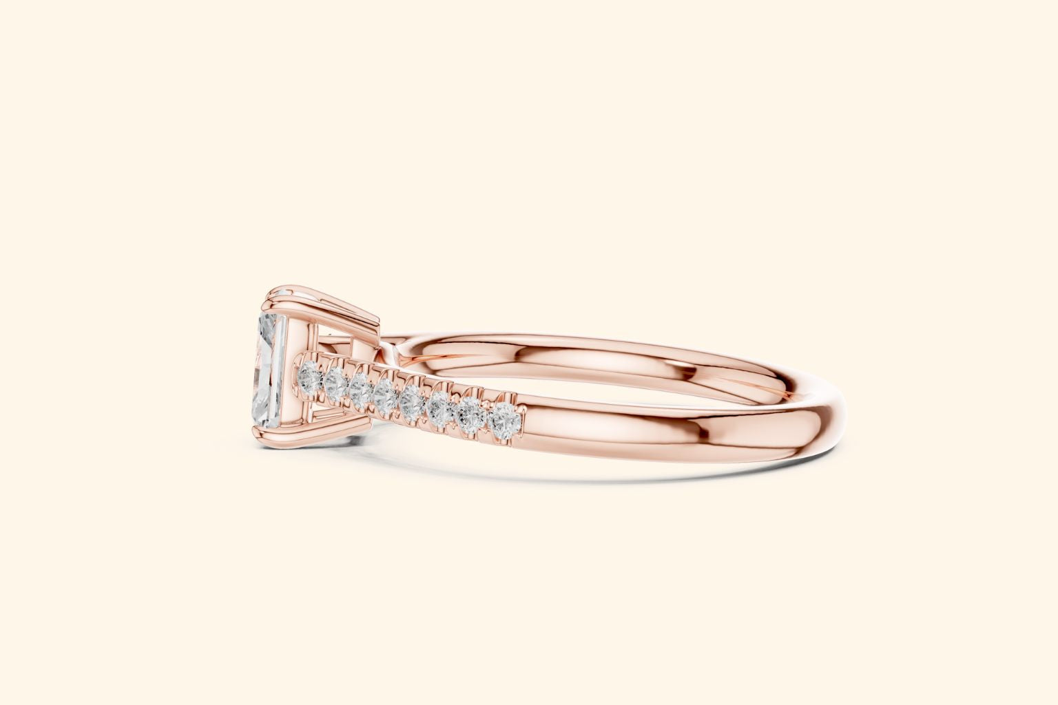 Close-up of a rose gold diamond ring featuring a rectangular radiant-cut center stone and diamond accents set into the tapering band.