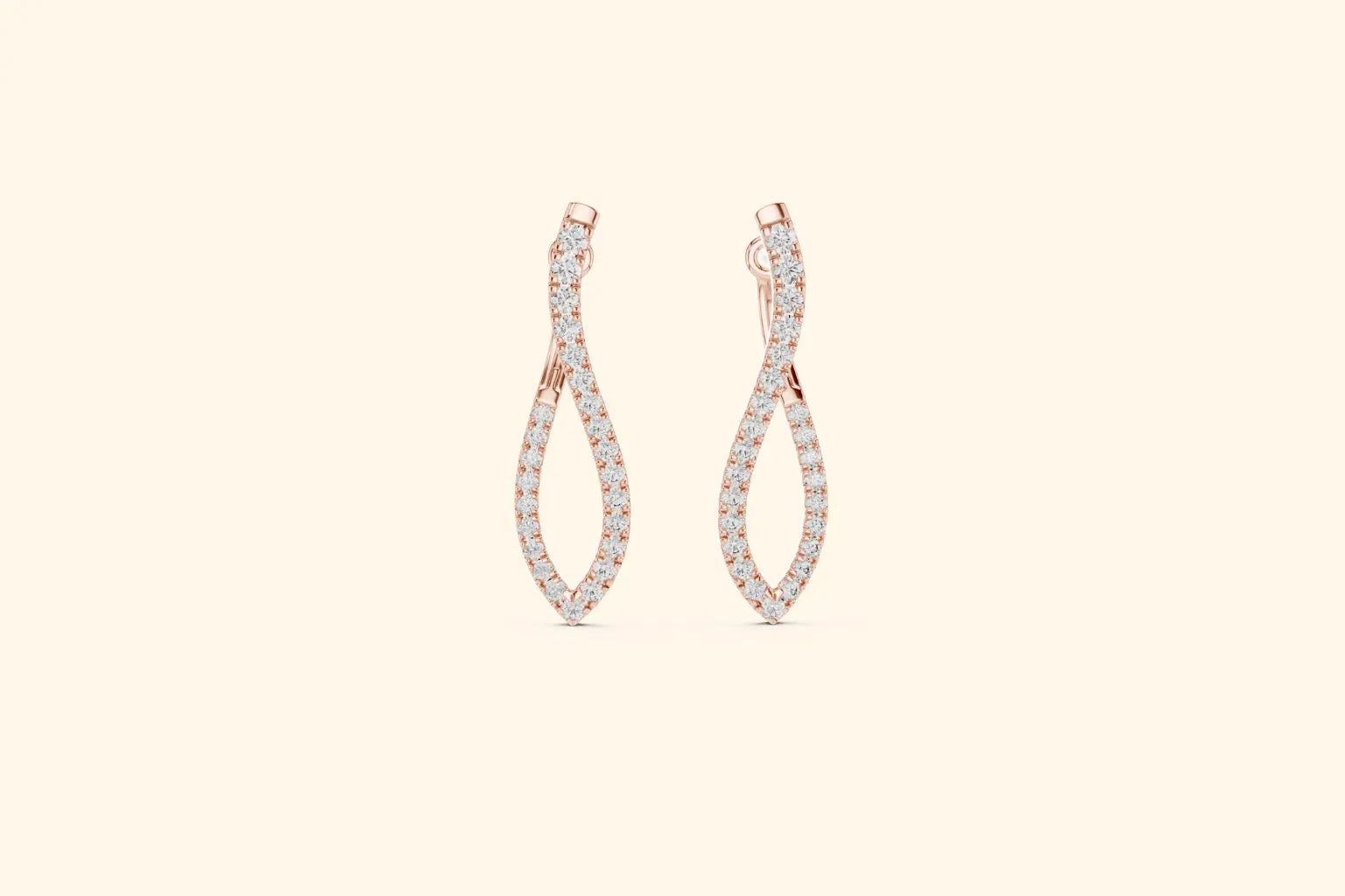 Pair of rose gold twisted infinity drop earrings with pave diamonds on a pale background