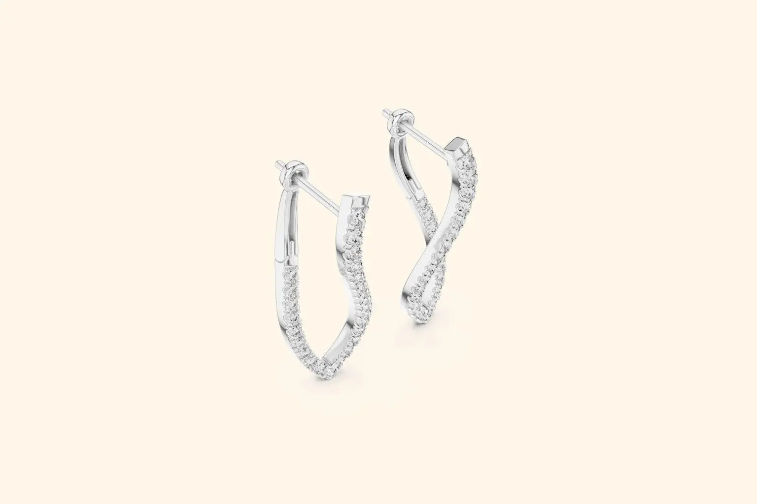 Pair of white gold twisted V-shape diamond drop earrings with pave setting on a pale background