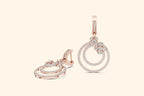 Rose gold jewelry set with circular designs on a light beige background