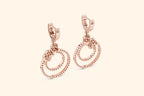 Rose gold hoop earrings on a light beige background