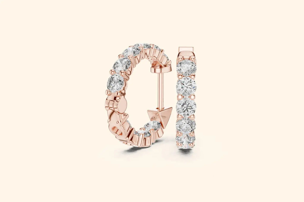 Pair of rose gold large round diamond eternity hoop earrings with gallery setting on a pale background