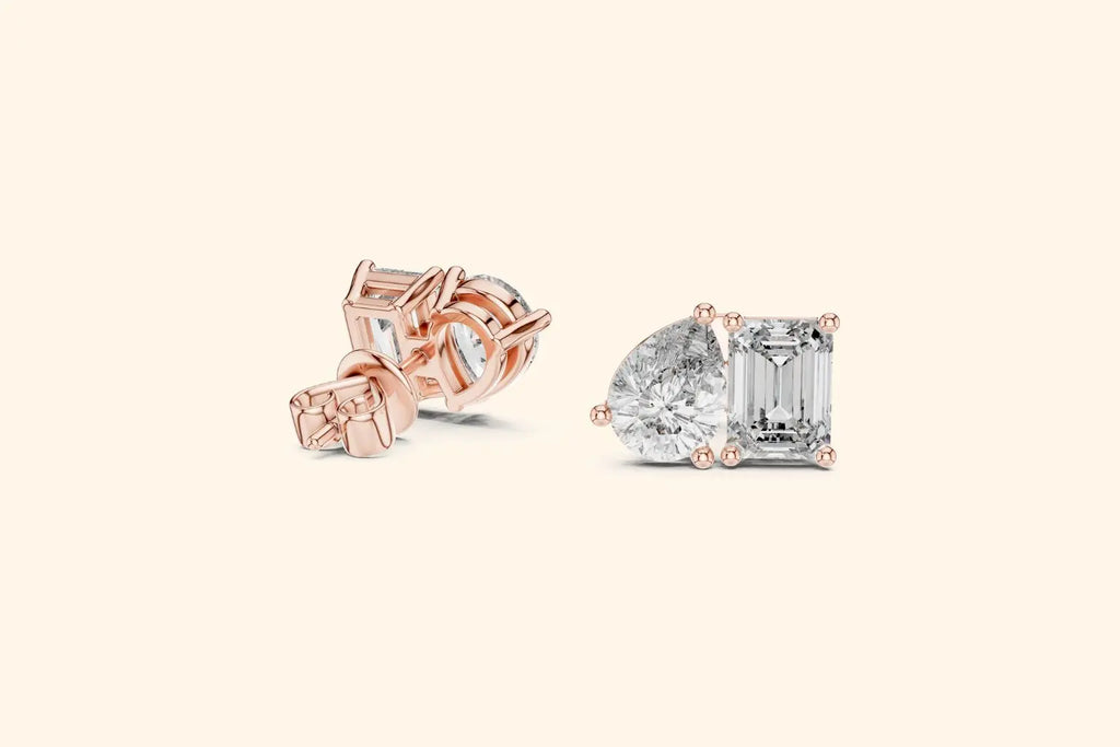 Pair of rose gold diamond stud earrings featuring a two-stone cluster of emerald-cut and pear-cut diamonds