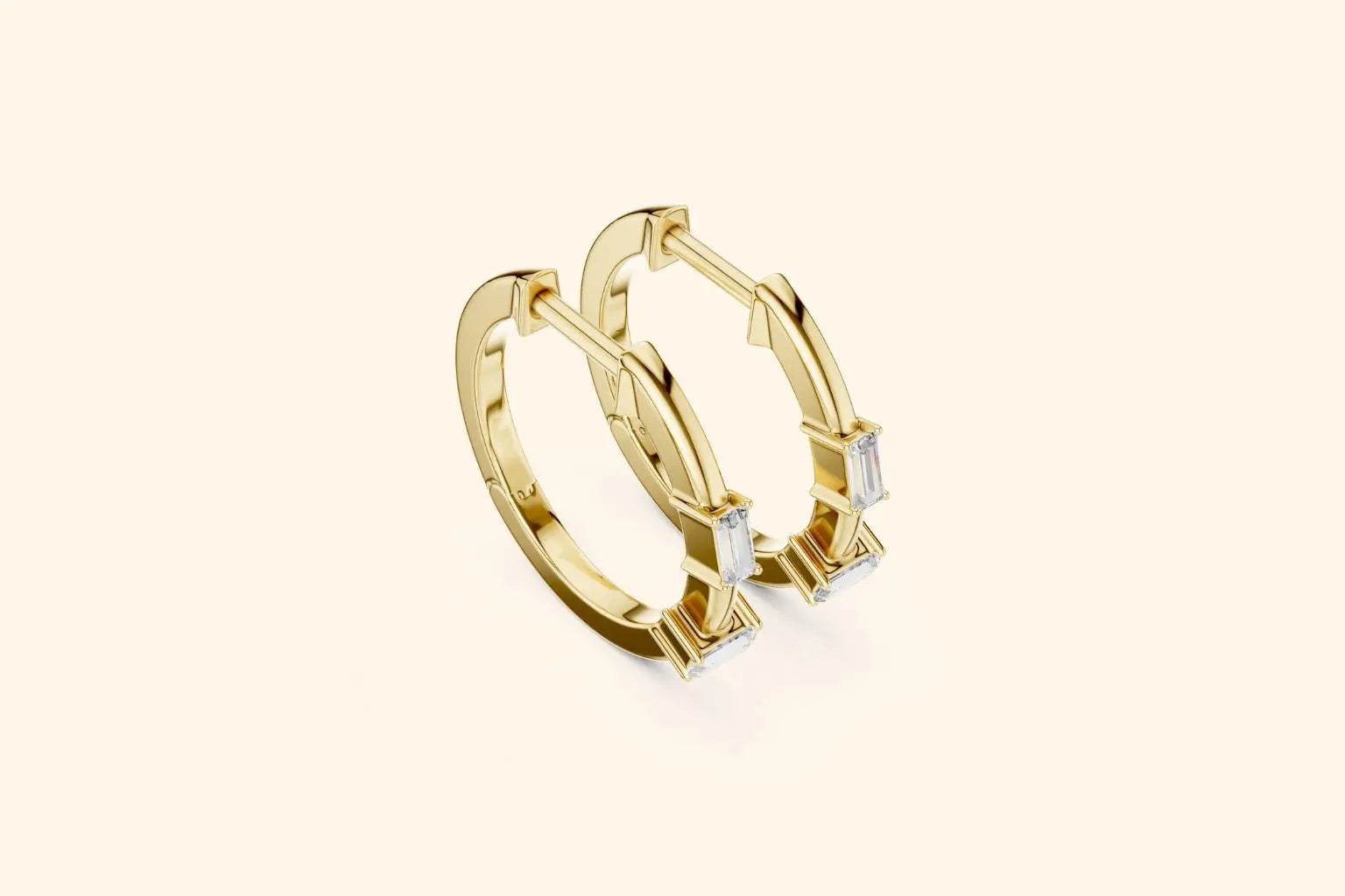 Gold hoop earrings with small diamonds on a light beige background