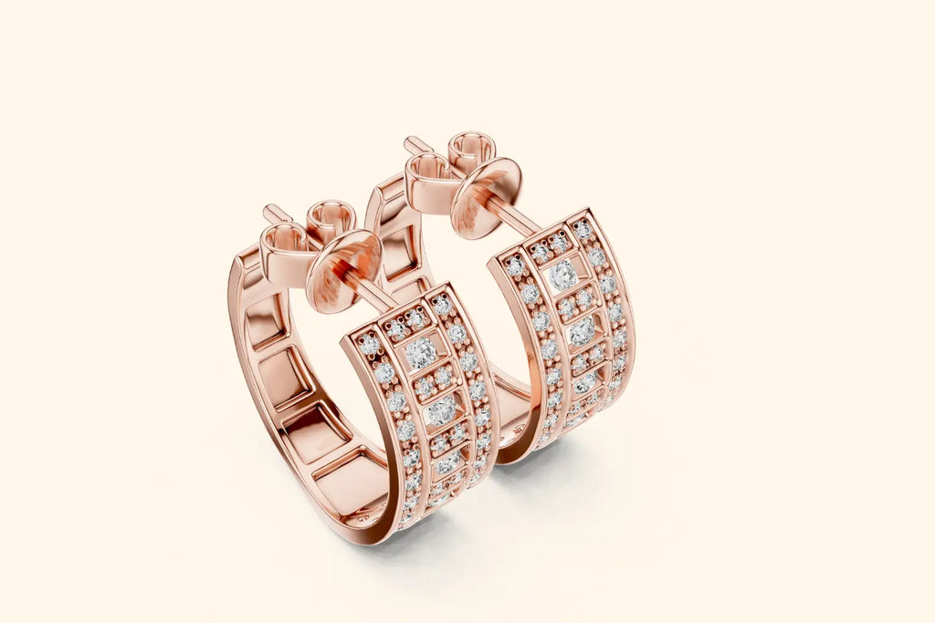 Rose gold hoop earrings with diamond accents on a light beige background