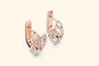 Rose gold earrings with diamond accents on a light beige background