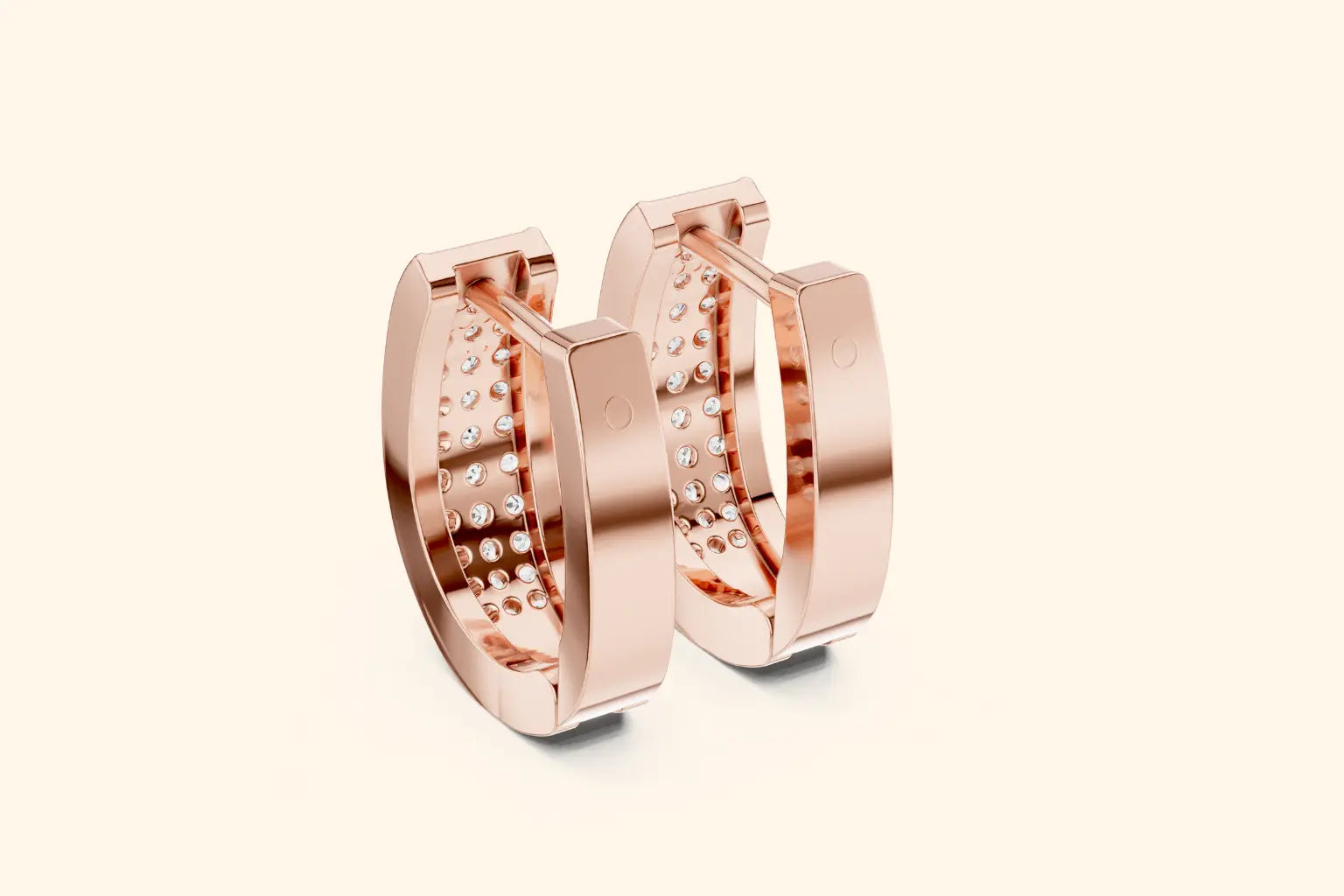 Rose gold hoop earrings with embedded stones on a light beige background