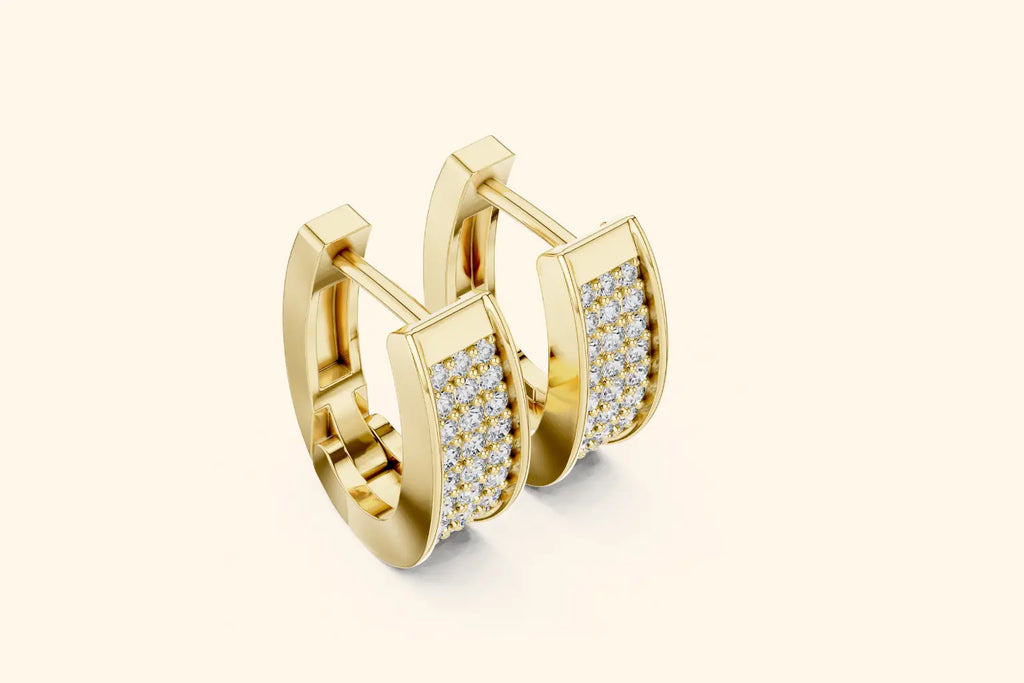 Gold hoop earrings with embedded diamonds on a light beige background