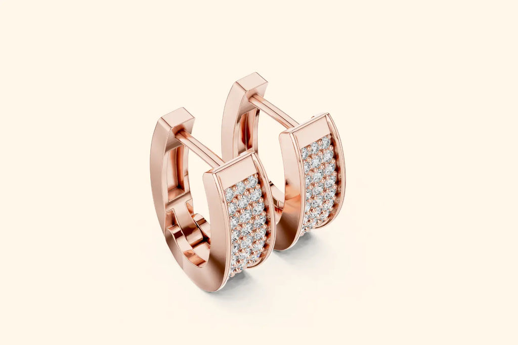 Rose gold hoop earrings with diamond accents on a light beige background