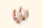 Rose gold hoop earrings with diamond accents on a light beige background