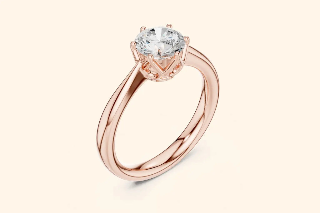 A three-quarter view of a delicate rose gold solitaire ring with a high-set brilliant diamond, emphasizing the thin, polished band and the intricate prong work.