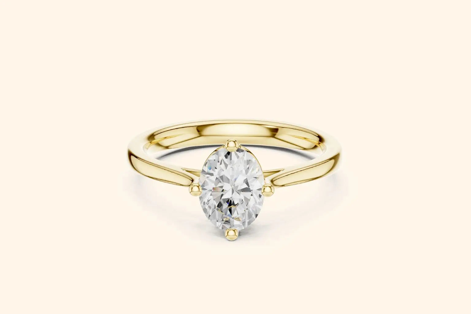 A classic solitaire engagement ring featuring an oval-cut diamond set in a sleek, four-prong compass style on a polished yellow gold band.
