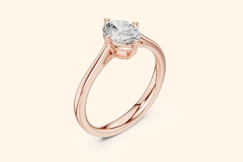 A three-quarter view of a delicate rose gold solitaire ring with a high-set oval diamond, emphasizing the thin band and the four-prong setting.