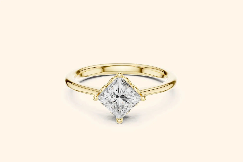 A modern solitaire engagement ring featuring a princess-cut diamond set diagonally in a four-prong setting on a polished yellow gold band.