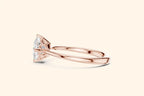 Side profile view of a polished rose gold engagement ring, showcasing the streamlined band and the elegant basket setting holding the diagonal square diamond.