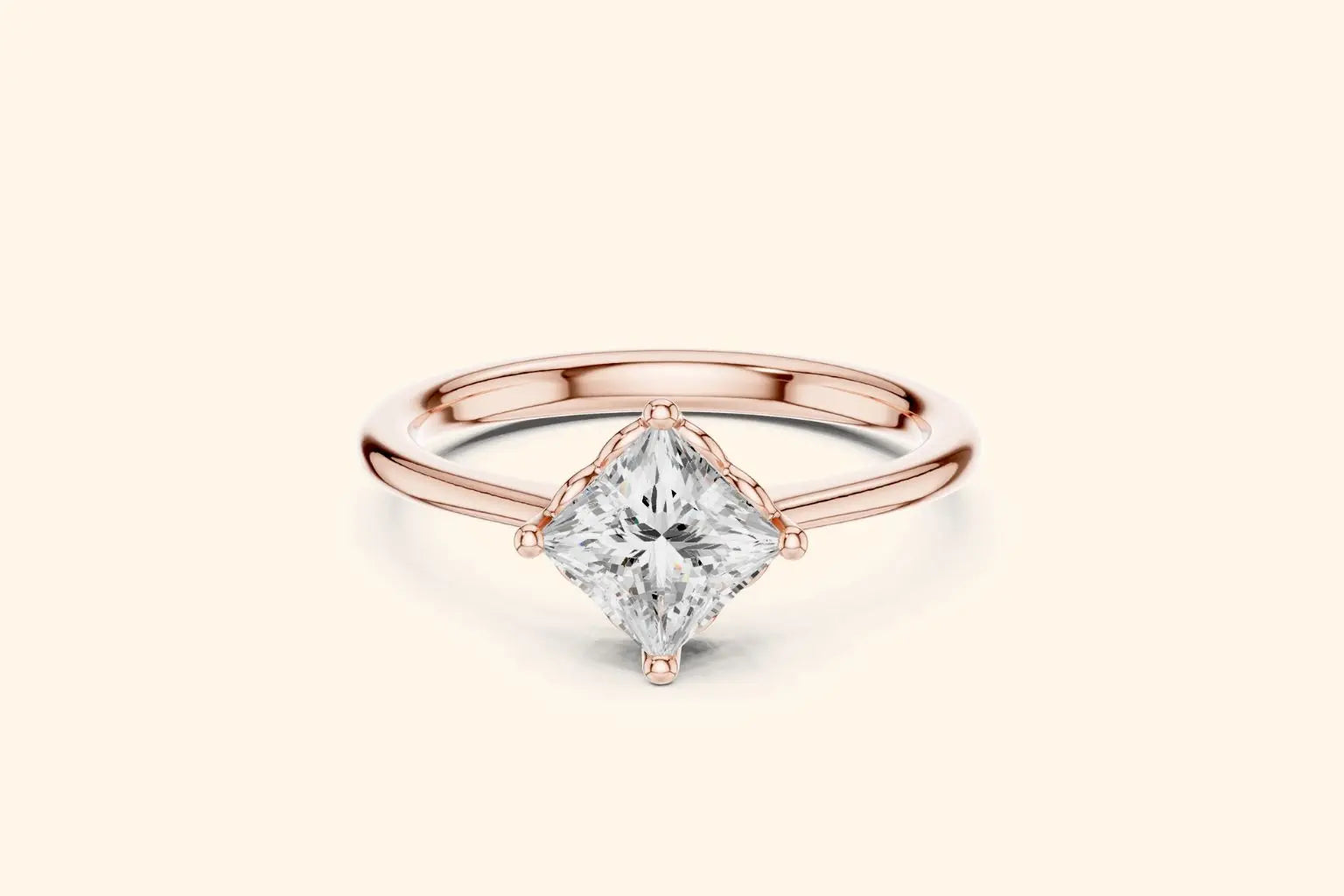 A modern solitaire engagement ring featuring a princess-cut diamond set diagonally in a four-prong setting on a polished rose gold band.