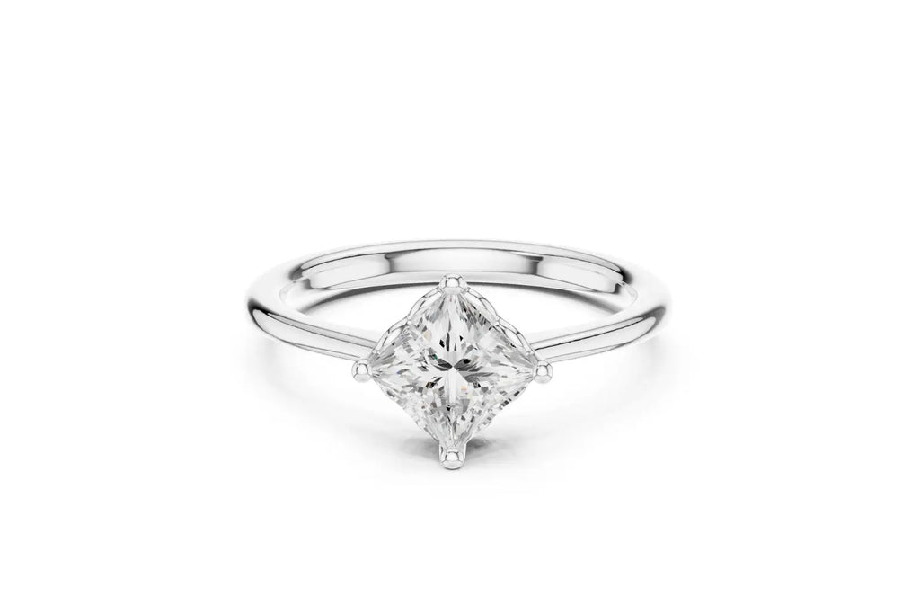 A modern solitaire engagement ring featuring a princess-cut diamond set diagonally in a four-prong setting on a polished white gold or platinum band.
