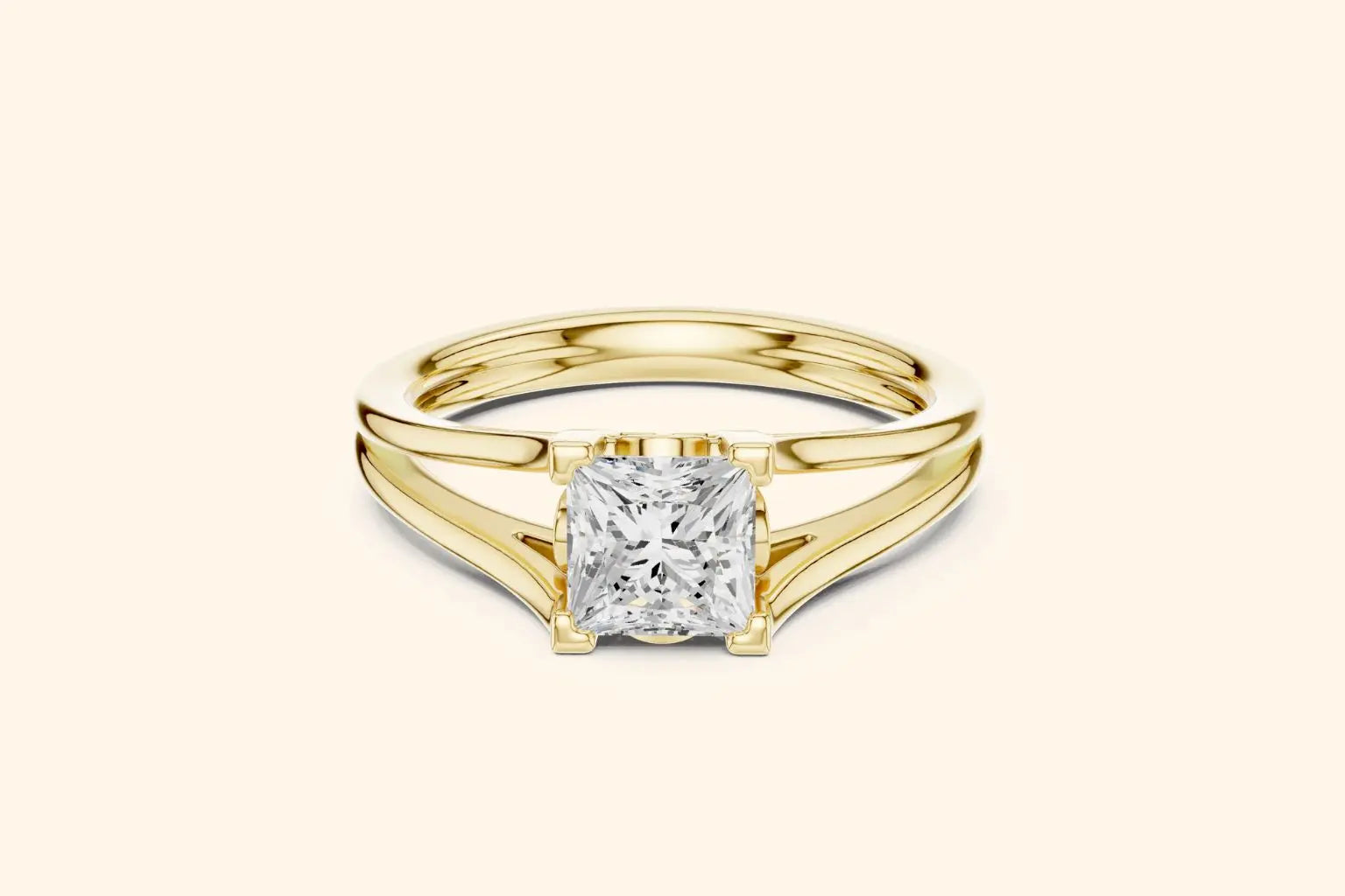 A modern solitaire ring featuring a rectangular diamond set on a wide, elegant split-shank band in polished yellow gold.