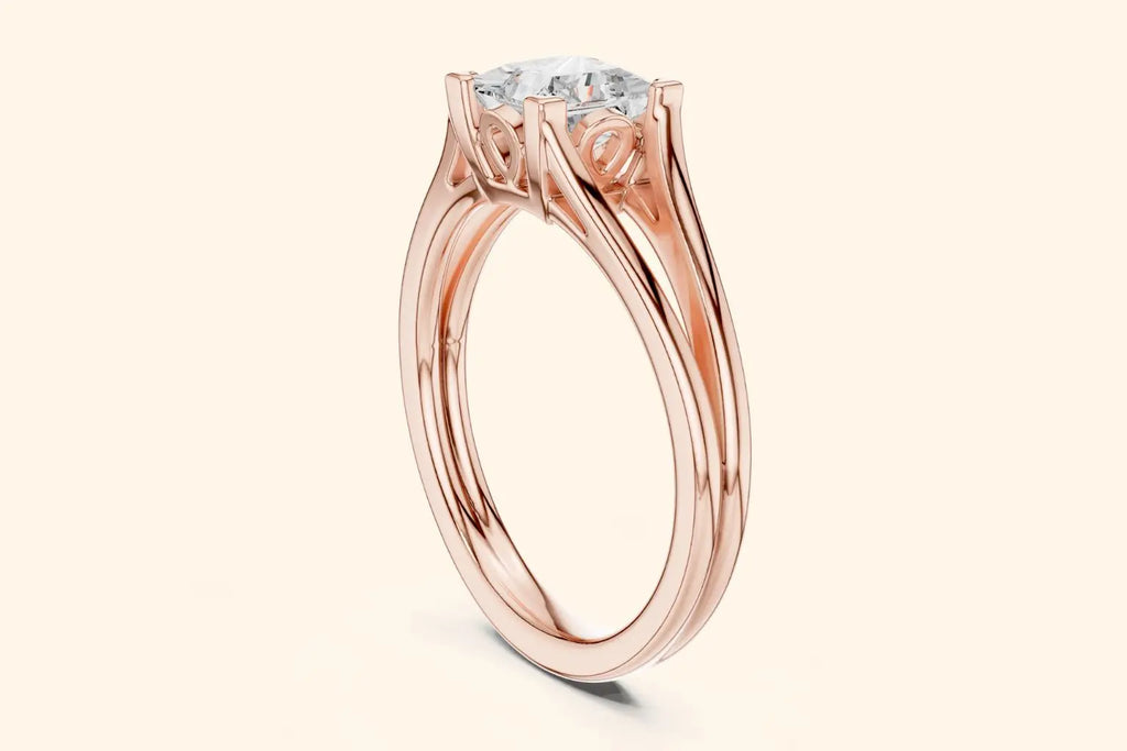 A side view of a rose gold solitaire ring, showcasing the open, split-shank band and the ornate basket setting that holds the rectangular diamond.