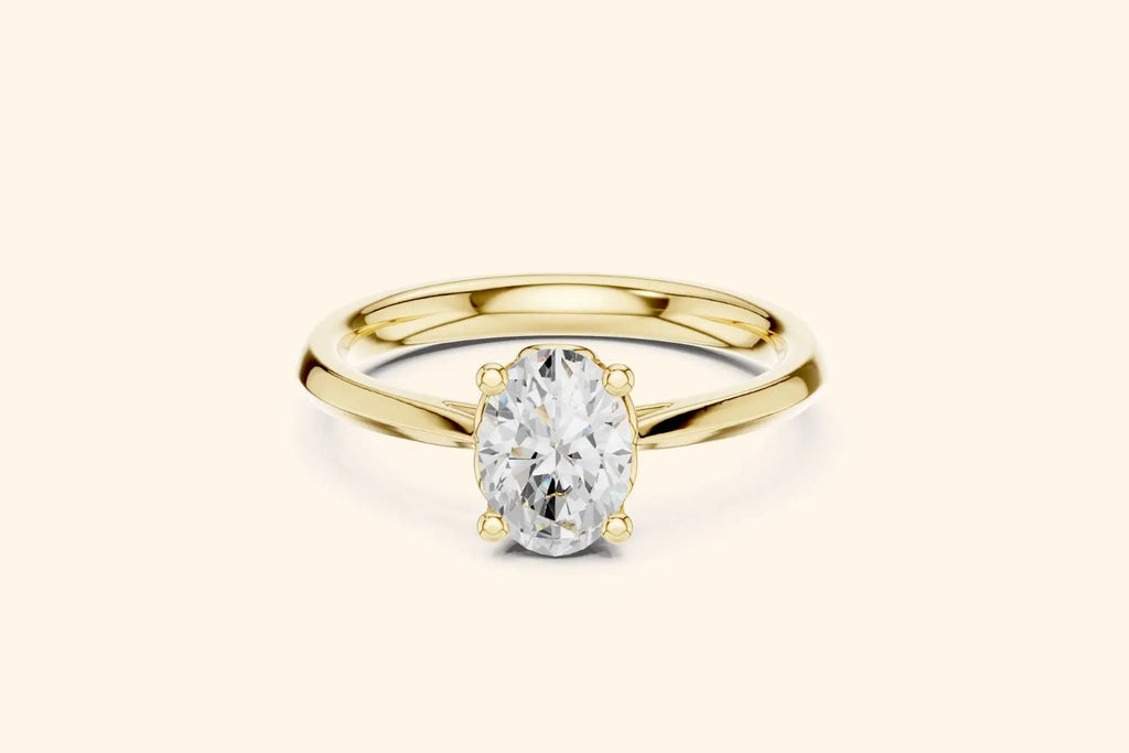 A classic solitaire engagement ring featuring an oval-cut diamond held by six prongs on a polished yellow gold band.