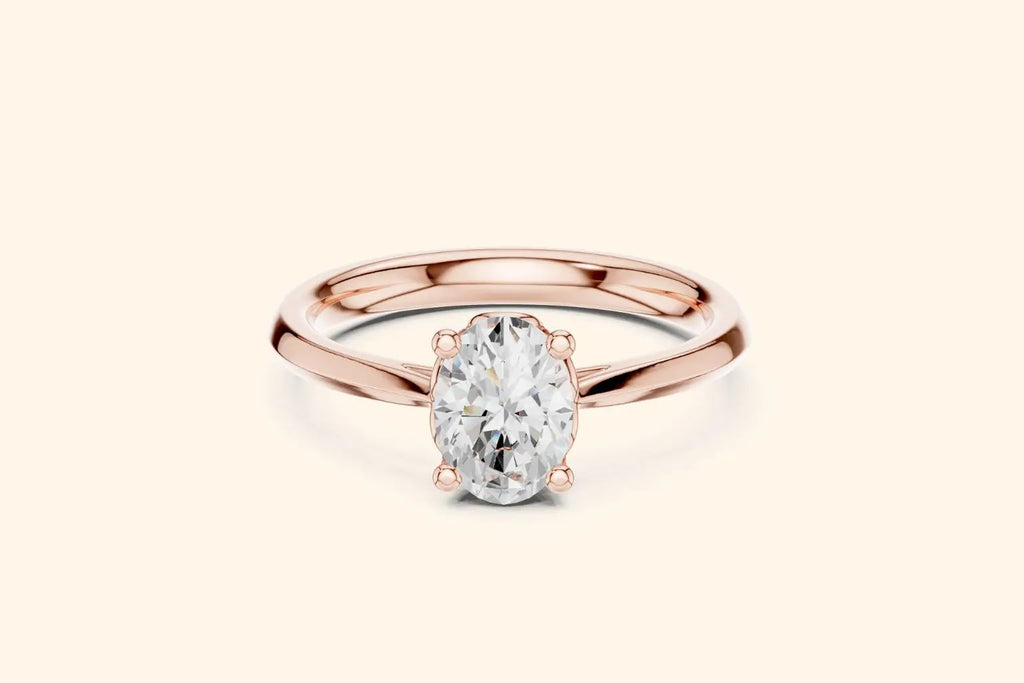 A classic solitaire engagement ring featuring an oval-cut diamond held by six prongs on a polished rose gold band.