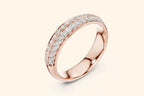 A sparkling rose gold band ring shown at a downward angle, with two parallel rows of pave-set round brilliant diamonds completely encircling the visible portion of the ring. The band has a smooth, rounded edge and a highly reflective surface.