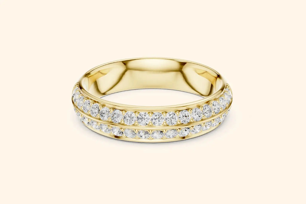 A broad, highly reflective gold band ring featuring two continuous, closely-set rows of round brilliant diamonds in a pave setting. The bright gold metal provides a rich, warm frame for the dazzling sparkle of the diamonds.