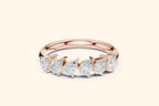 A front view of a half-band ring in polished rose gold. It features a row of six brilliant pear-shaped diamonds set horizontally along the top, with the pointed ends of the diamonds aligned in the same direction.