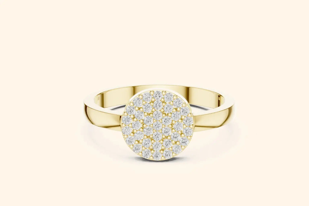 A straight-on view of a striking ring in rich pure gold or yellow gold. The ring features a broad, round top surface completely set with small, brilliant pave diamonds.