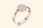 An angled three-quarter view of a polished rose gold ring. The design features a large, round plate completely covered in pave-set diamonds, elevated on a thick, shiny band.