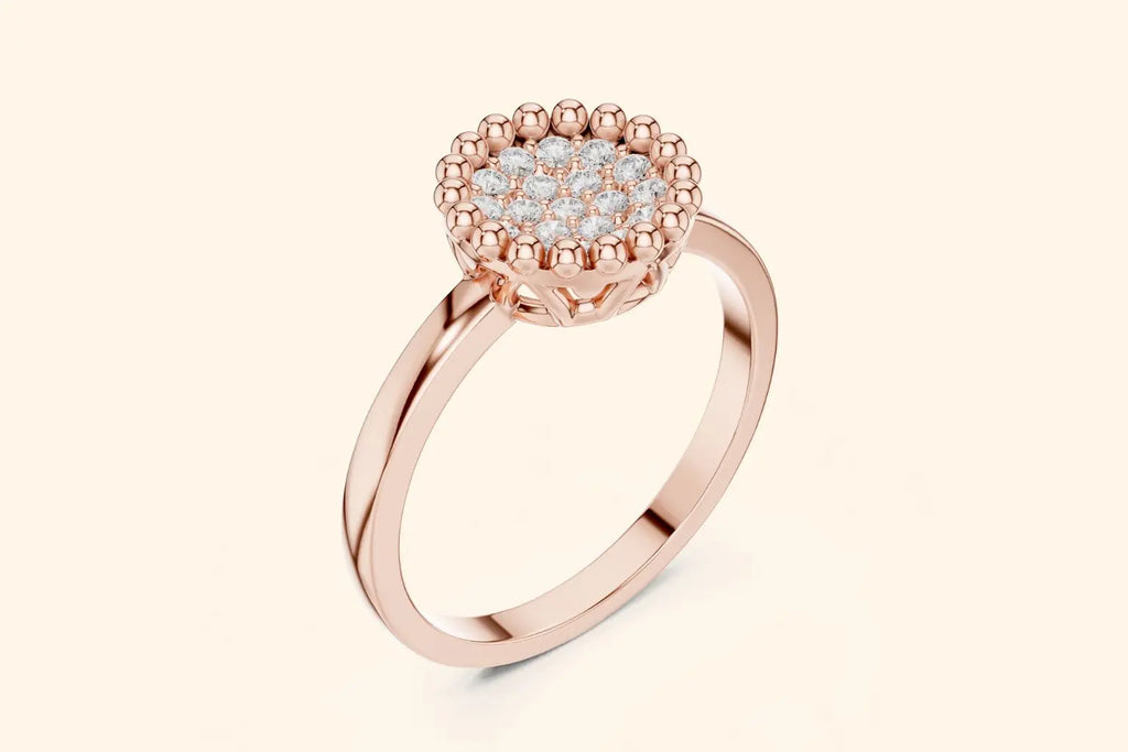 A three-quarter view of a delicate rose gold ring with a round, elevated setting. The head features a central cluster of pave diamonds surrounded by a distinctive beaded milgrain edge.