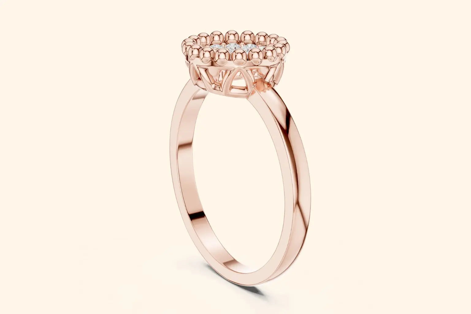 A side-profile view of a delicate rose gold ring showing the high-set, round head. The setting features a diamond cluster framed by a beaded halo on a slender, polished band.