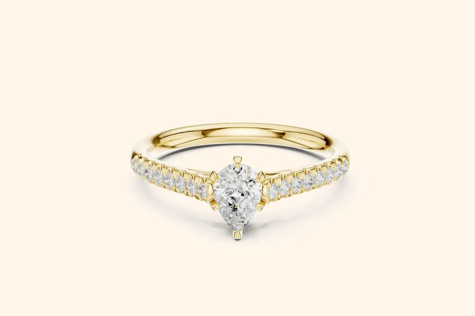 Elegant pure gold engagement ring featuring a sparkling pear-cut center diamond and smaller diamonds set along the band.
