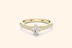 Elegant pure gold engagement ring featuring a sparkling pear-cut center diamond and smaller diamonds set along the band.