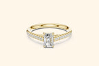 ellow gold diamond engagement ring with a horizontal radiant-cut center stone and diamonds set along the band.