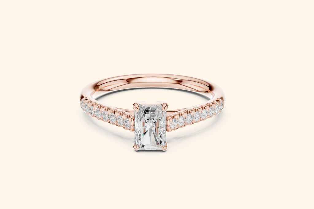 Elegant rose gold engagement ring with a brilliant radiant-cut diamond and micro-pavé shoulder diamonds.