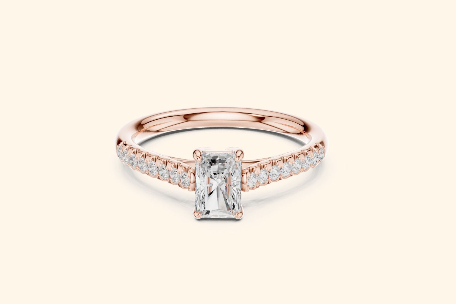 Elegant rose gold engagement ring with a brilliant radiant-cut diamond and micro-pavé shoulder diamonds.