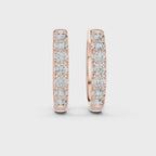 Pair of rose gold diamond hoop earrings with prong setting on a white background