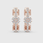 A pair of rose gold huggie earrings featuring a complex, openwork snowflake