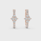 Pair of rose gold huggie hoop earrings with a centered four-stone diamond floral cluster and small accent diamonds.