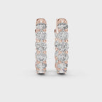 Pair of rose gold inside-out eternity diamond hoop earrings on a white background
