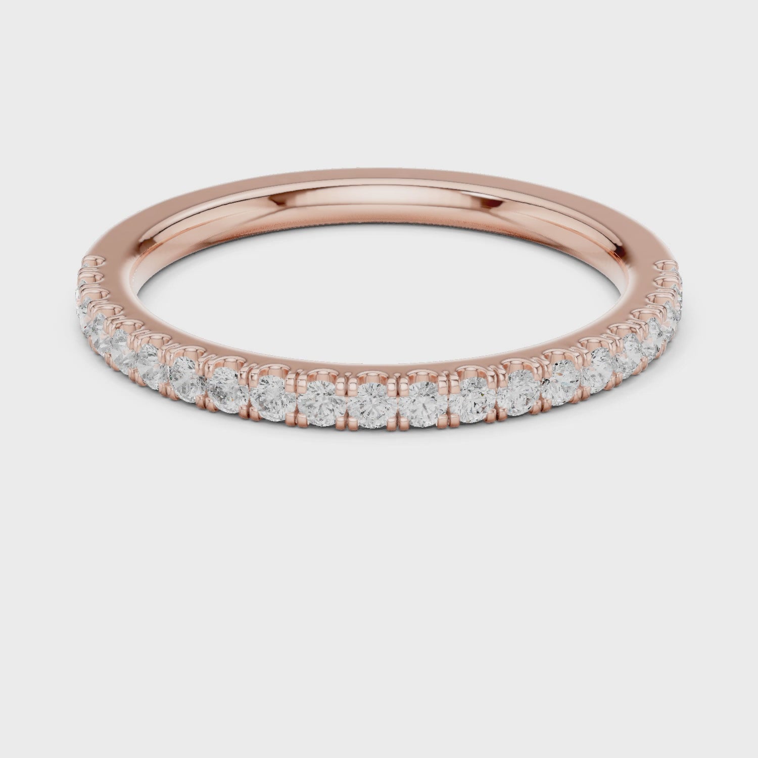 Rose gold ring with round-cut diamonds in a polished, elegant band design.