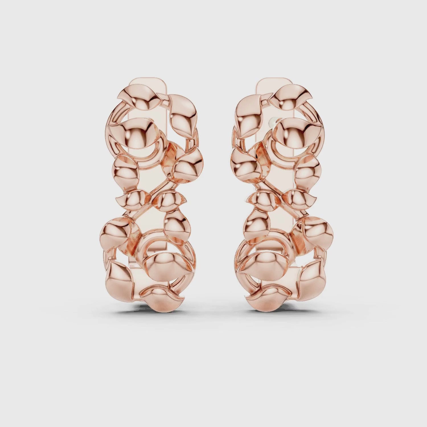 A pair of huggie earrings featuring a detailed