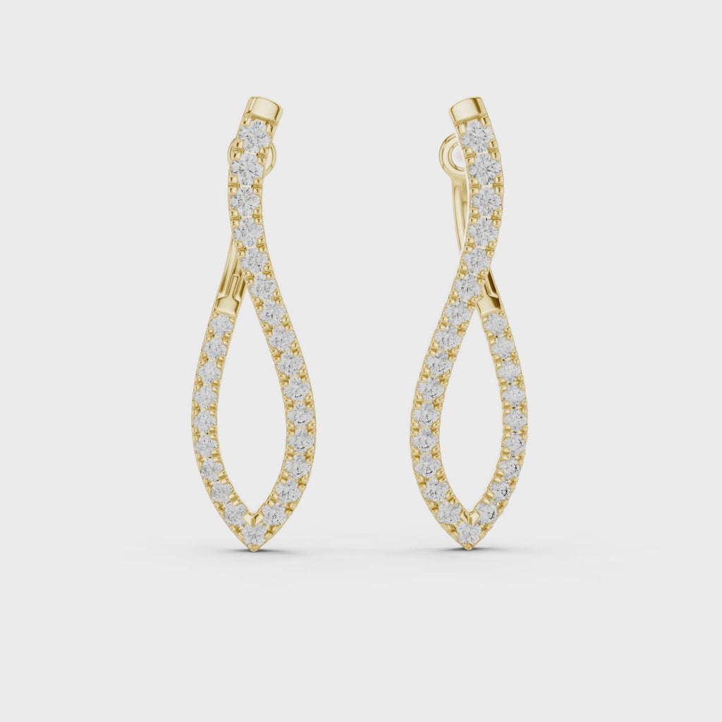 Pair of yellow gold twisted infinity hoop earrings with pave-set diamonds on a white background